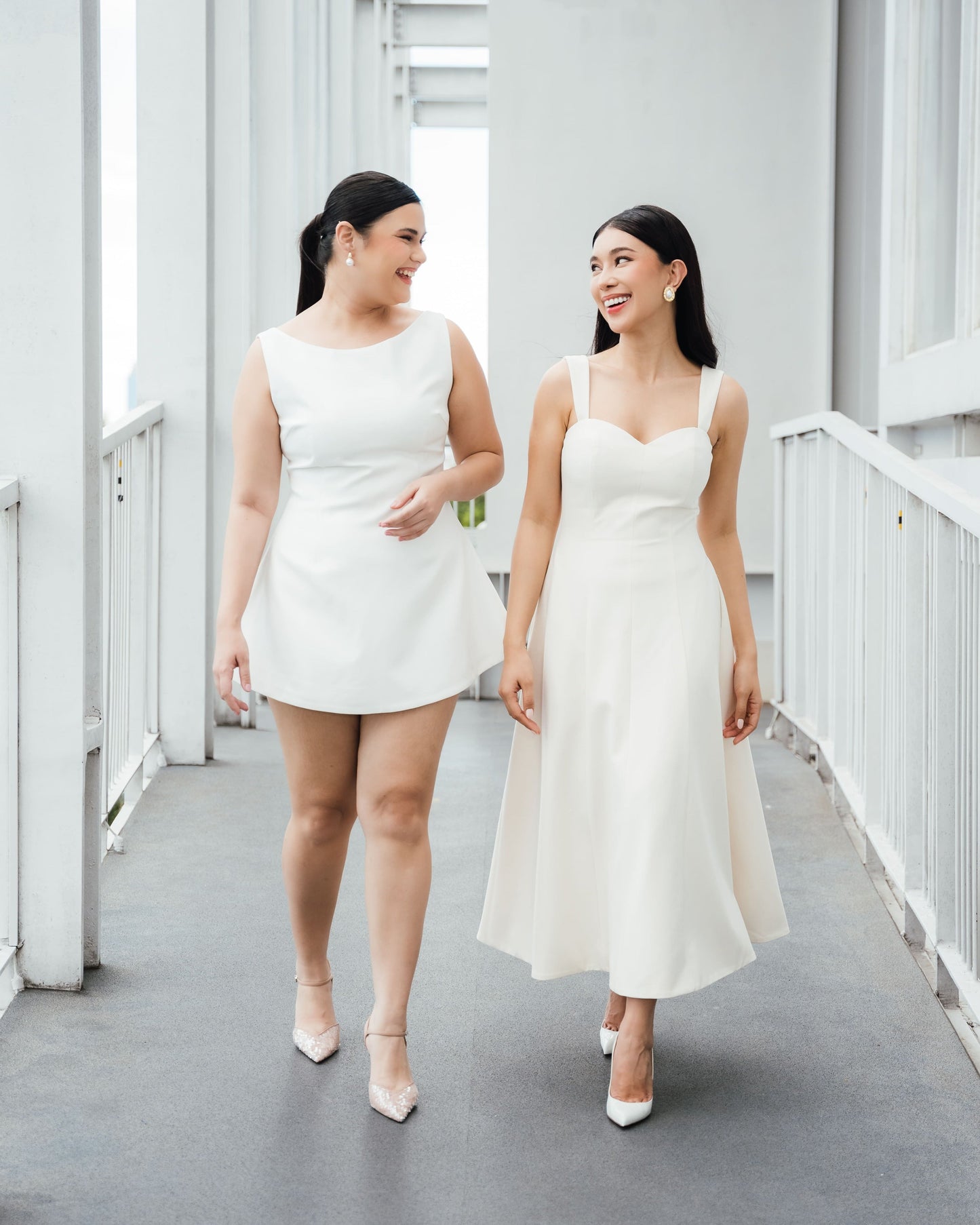 two women wearing white/ivory Fleur Elize dresses
