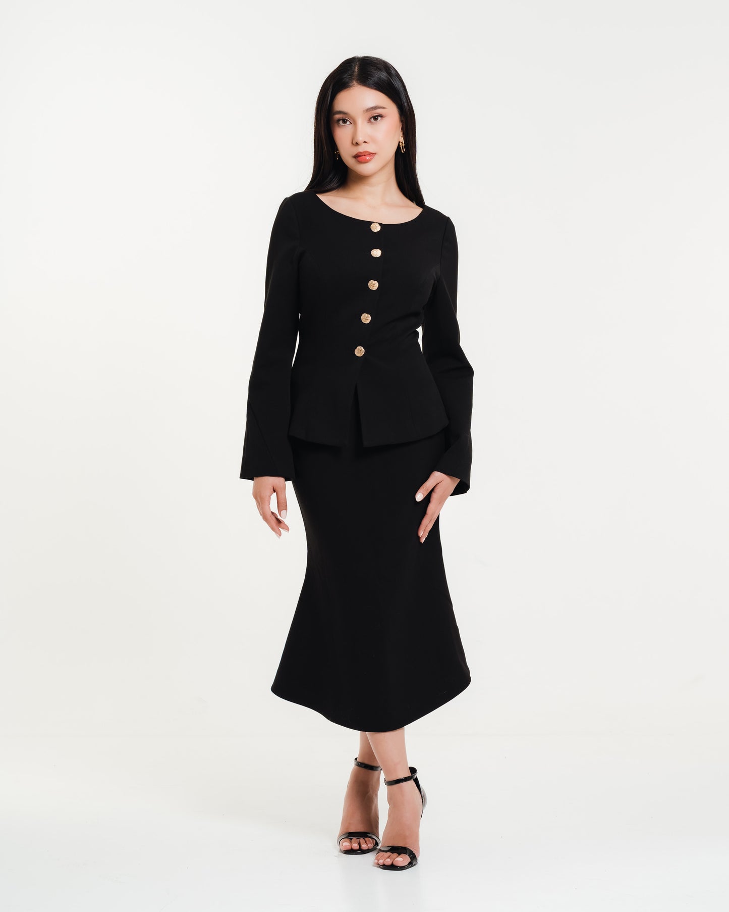 Fleur Elize black long-sleeve midi dress with gold button detailing — elegant women’s boutique outfit photographed in a minimalist studio setting