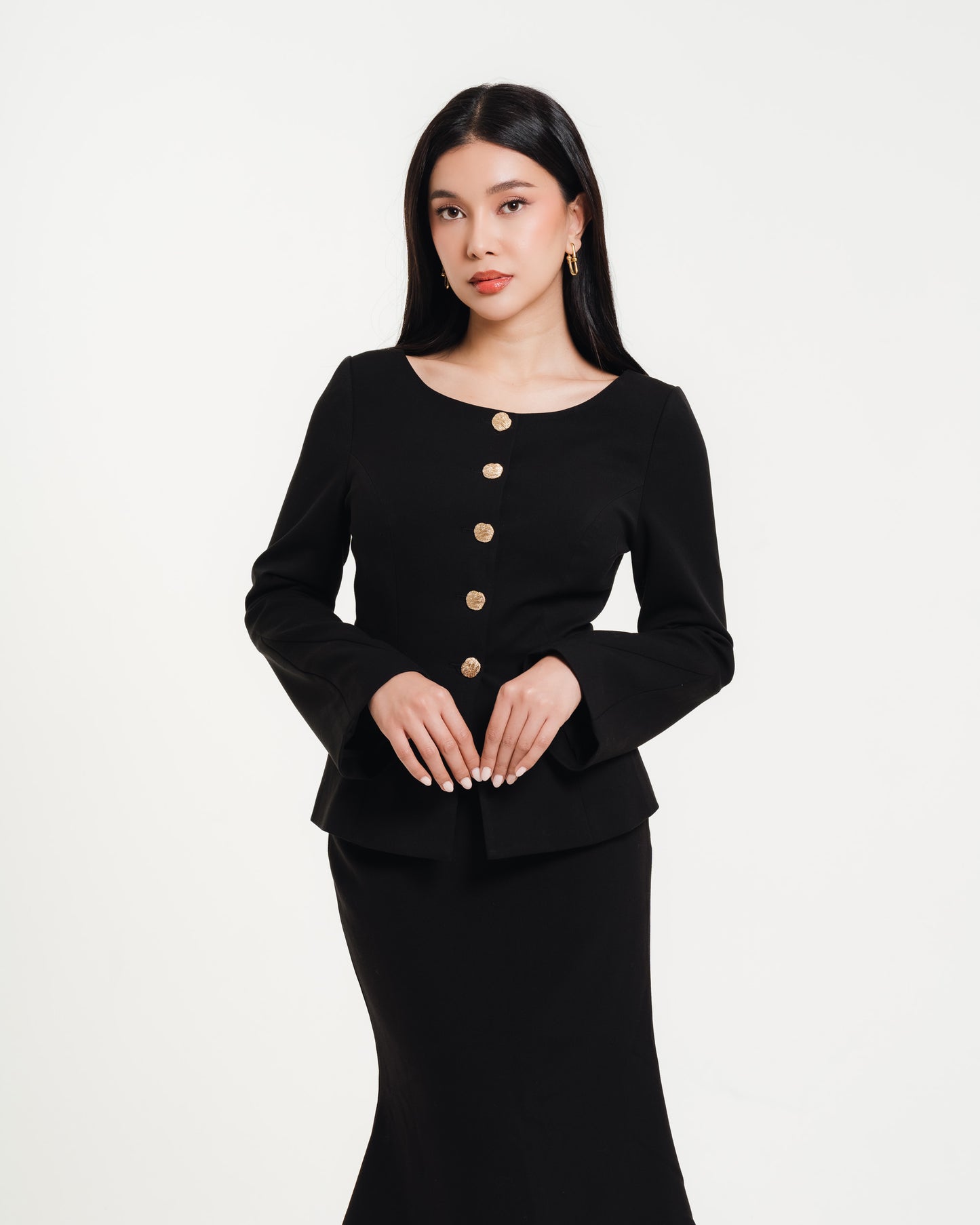 Fleur Elize black long-sleeve midi dress with gold button accents — close-up view of elegant women’s boutique fashion photographed in a minimalist studio setting