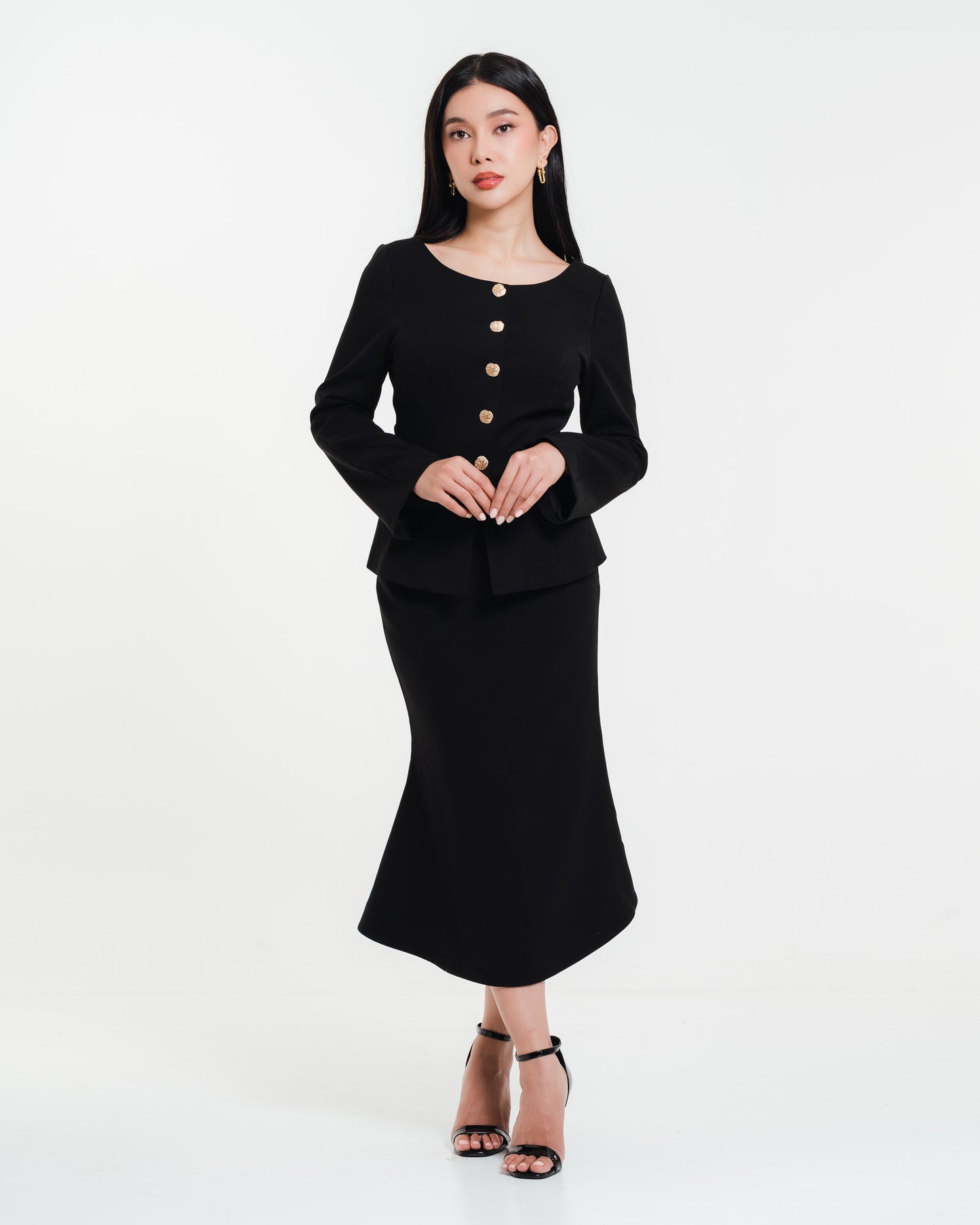 Fleur Elize black mermaid skirt with matching long-sleeve top featuring gold buttons — modern minimalist look